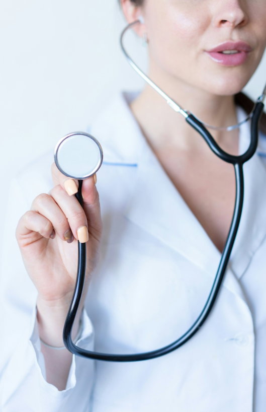 a woman in a white shirt holding a stethoscope